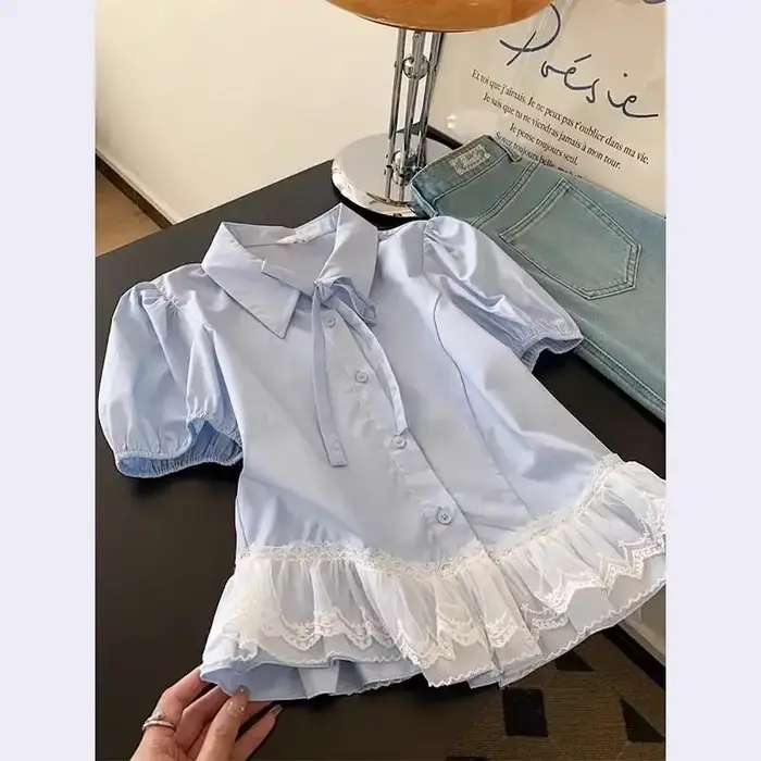 Chemise pour femme en bleu clair avec col à nœud papillon et ourlet en dentelle