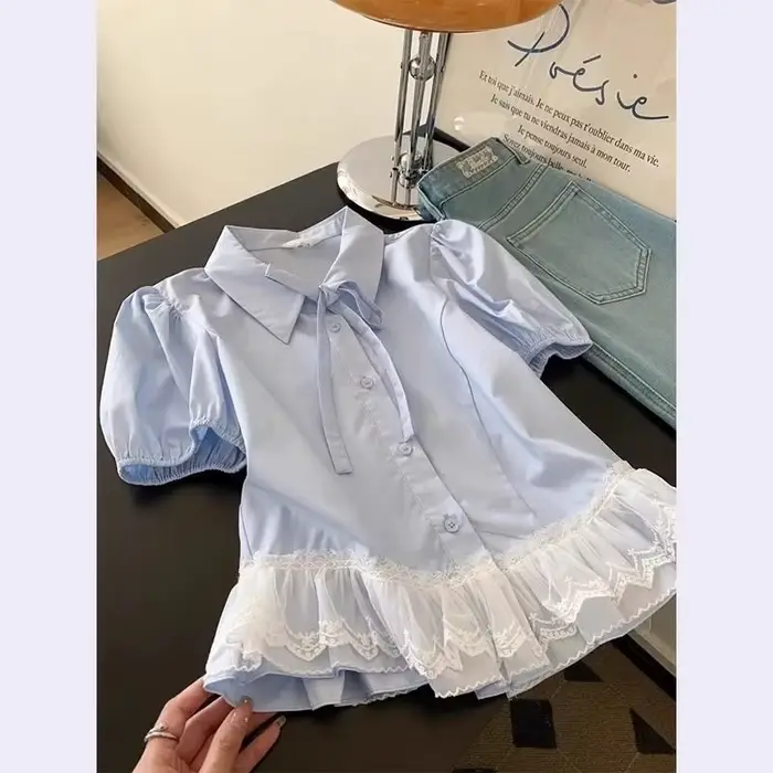 Chemise pour femme en bleu clair avec col à nœud papillon et ourlet en dentelle